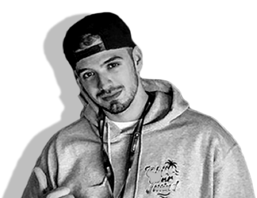 A black and white photograph of artist Pavle. He has short dark hair and a beard, and is weaing a black backwards snapback and light hoodie.
